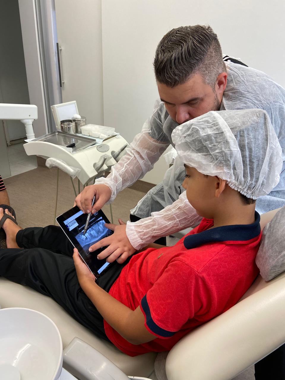 Dr. Henrique mostrando a radiografia a um paciente durante a avaliação
